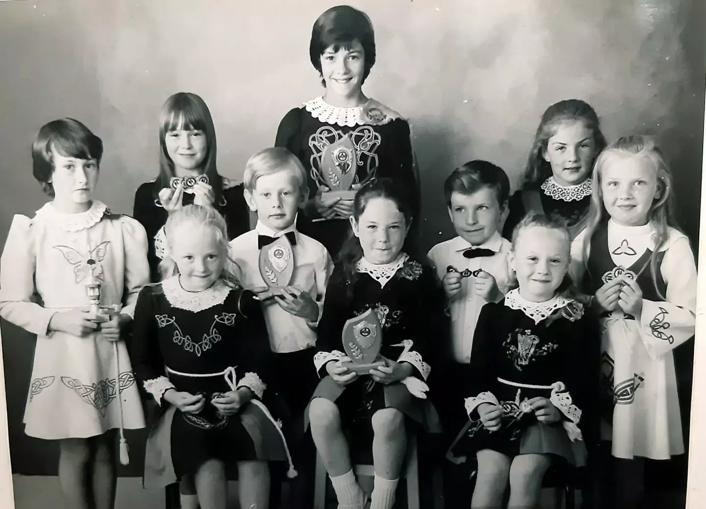 A group of young female Irish dancers gathered with trophies